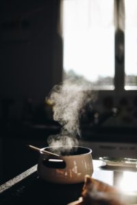 a pot sitting on a stove in front of a window